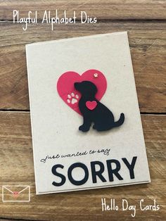 a card with a black dog holding a pink heart and the words sorry written on it