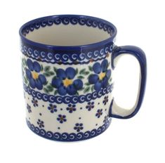 a blue and white coffee cup with flowers on the inside, sitting in front of a white background