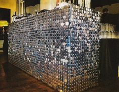 a large stack of beer cans sitting on top of a wooden floor