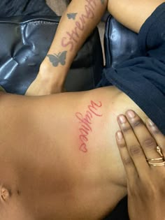 a woman laying on top of a couch with tattoos on her stomach and hand next to her chest