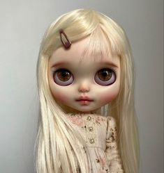 a doll with long blonde hair and big eyes