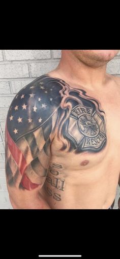 a man's chest with an american flag and fire department tattoo on it, next to a brick wall