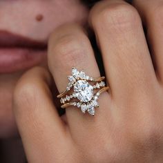 a woman's hand with a diamond ring on top of her finger and an engagement band