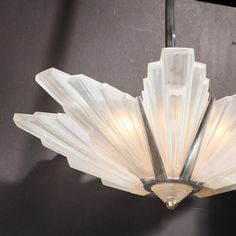 an art deco chandelier with frosted glass petals hanging from it's ceiling