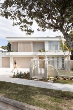 A women walks up the driveway of a bright white two storey home, surrounded by trees and sprawling green lawns. Coastal Mediterranean Interior Design, Modern Beach House Exterior, Interior Design Studios, Coastal Mediterranean, Abi Interiors, Rooftop Gardens, Mediterranean Interior Design, Mediterranean Interior, Beach House Exterior