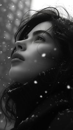 black and white photograph of a woman in the snow with her eyes closed looking up