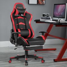 a black and red office chair sitting in front of a desk with a computer monitor