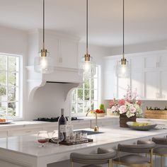 a large kitchen with white cabinets and marble counter tops, gold bar stools on the island