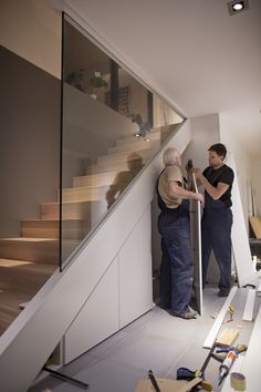 two men are working on the stair railing