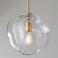 a clear glass light fixture with a gold metal fitting on the top and bottom part