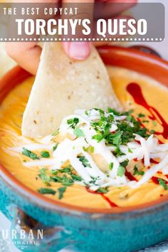 a hand dipping tortilla into a bowl filled with quesadilla soup