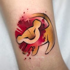 a tattoo on the leg of a person with a lion and red paint splattered on