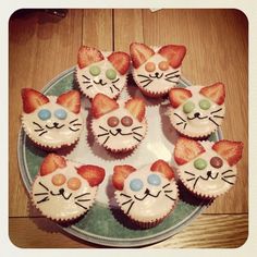 cupcakes decorated like cats with strawberries on top