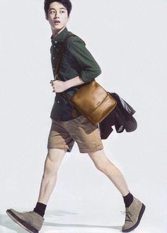 a young man carrying a brown bag while walking across a white floor with no shoes on