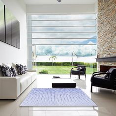 a living room with white furniture and large windows