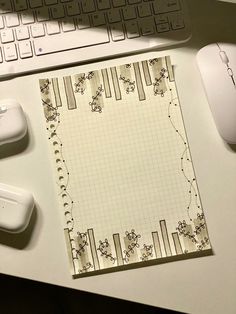 a notepad sitting on top of a desk next to a computer mouse and keyboard