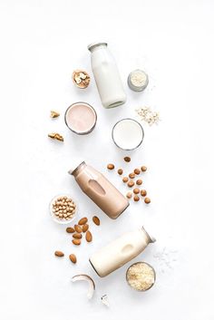 an assortment of milks and nuts on a white surface