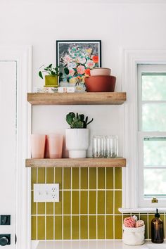 two wooden shelves filled with pots and plants on top of a white kitchen countertop