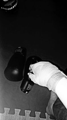 a black and white photo of a person's hand with gloves on, next to a computer mouse