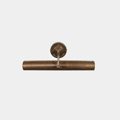 an antique brass toilet roll holder on a white background