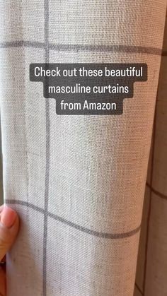 someone's hand holding up the back of a curtain with text on it that reads, check out these beautiful masculine curtains from amazon