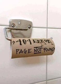 a roll of toilet paper is hanging on the wall next to a metal holder that says page not found