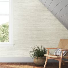 a wooden chair sitting in front of a window next to a potted plant on top of a hard wood floor