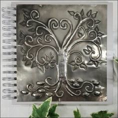 a spiral notebook with a tree design on it