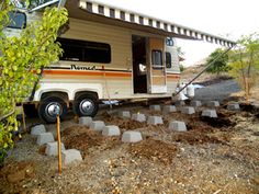 an rv is parked in the dirt near some trees