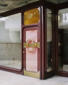 an open door with a gold handle on it and some windows in the back ground