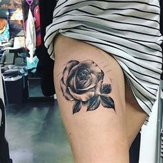 a woman's thigh with a rose tattoo on it