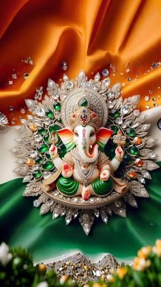 the statue of lord ganesh is surrounded by green and white flowers on an orange silk background