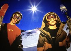 two people wearing skis and goggles standing next to each other