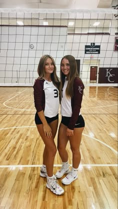 two girls in volleyball uniforms posing for the camera