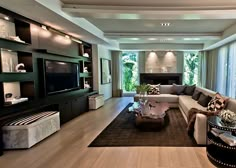 a living room filled with furniture and a flat screen tv mounted on a wall above a fireplace