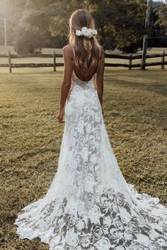 the back of a woman's wedding dress in a field