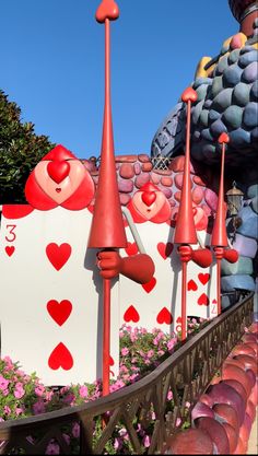 several red and white hearts are on the side of a building that is decorated with pink flowers