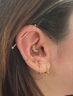 a woman's ear with three different types of piercings