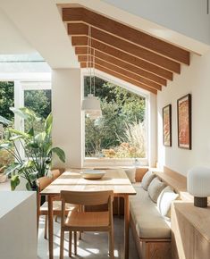 a living room with a couch, table and chairs next to a large open window