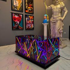 a statue is next to a colorful display in a room with art on the walls