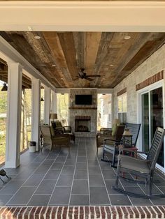 a covered porch with chairs and a fireplace