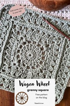 the granny wheel granny square is on top of a table next to a wooden bowl