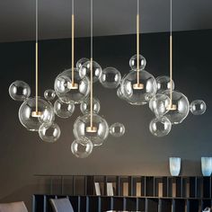 a modern chandelier hanging from the ceiling in a room with black walls and furniture