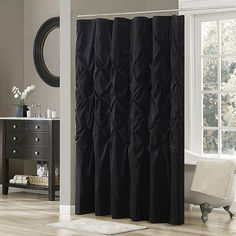 a black shower curtain in a bathroom next to a window