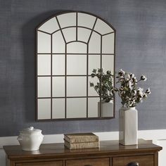 a table with two vases and a mirror on it next to a dresser in a room