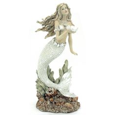 a figurine of a mermaid holding a pearl in her hand and sitting on a rock