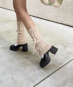 a woman's legs wearing high heeled boots and socks with laces on them