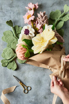 someone is wrapping flowers in brown paper