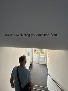 a man is walking down the stairs with his back to the camera as he looks up