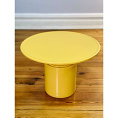 a yellow table sitting on top of a wooden floor